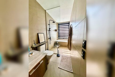 Bathroom with rain shower, bathtub and marble-top vanity in a 2BR corner condo for sale at The Reef, Mactan