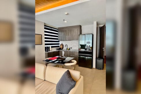 Open kitchen beside the dining area with subway-tile backsplash in a 2BR corner condo for sale at The Reef, Mactan