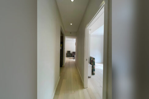 Hallway with oak-look floors leading to the living area