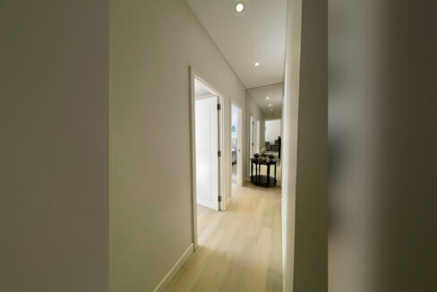 Hallway to the bedrooms with a mirrored end wall