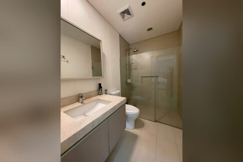 Bathroom with a stone-look vanity, framed mirror and walk-in glass shower