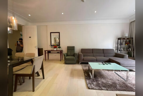 Living area with a grey sectional and recliner beside the dining table