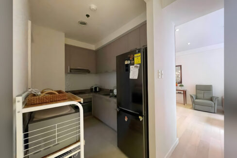 Kitchen with taupe cabinetry, a range hood and a refrigerator