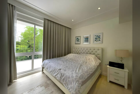 Main bedroom with full-height windows looking out to bamboo and trees