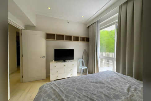 Main bedroom with built-in wall cubbies and a glass door to the garden